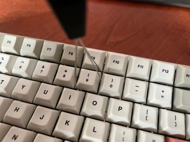 Keycap puller with its wires diagonally underneath a keycap