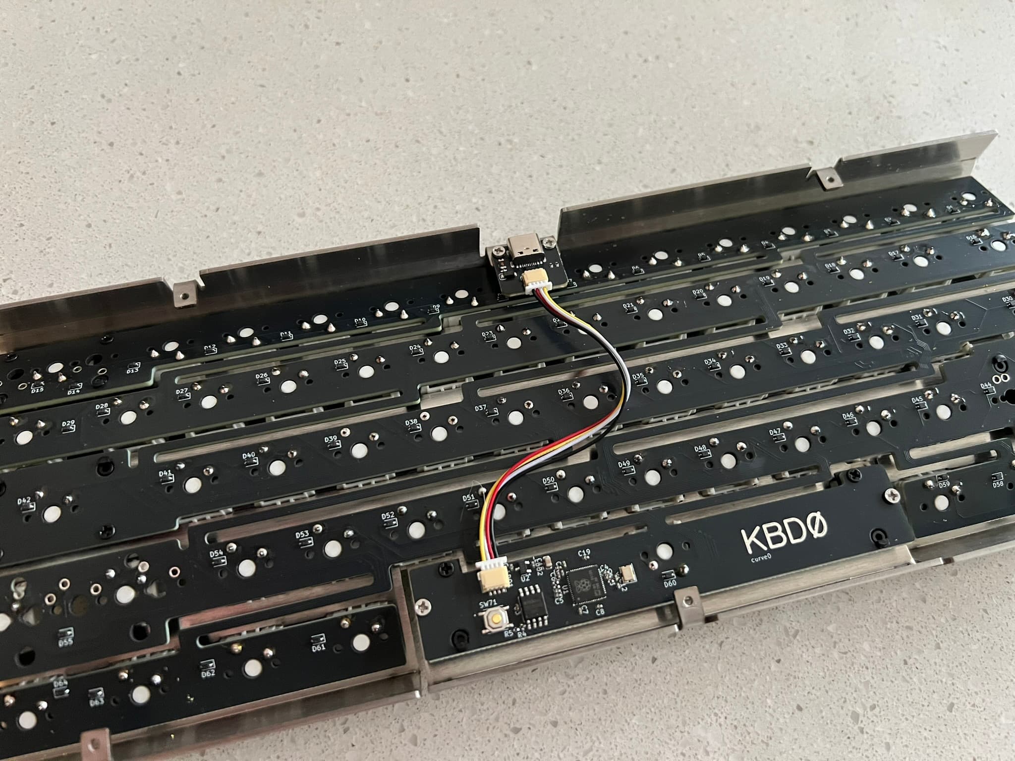 Daughterboard screwed into plate and connected to PCB via SH cable