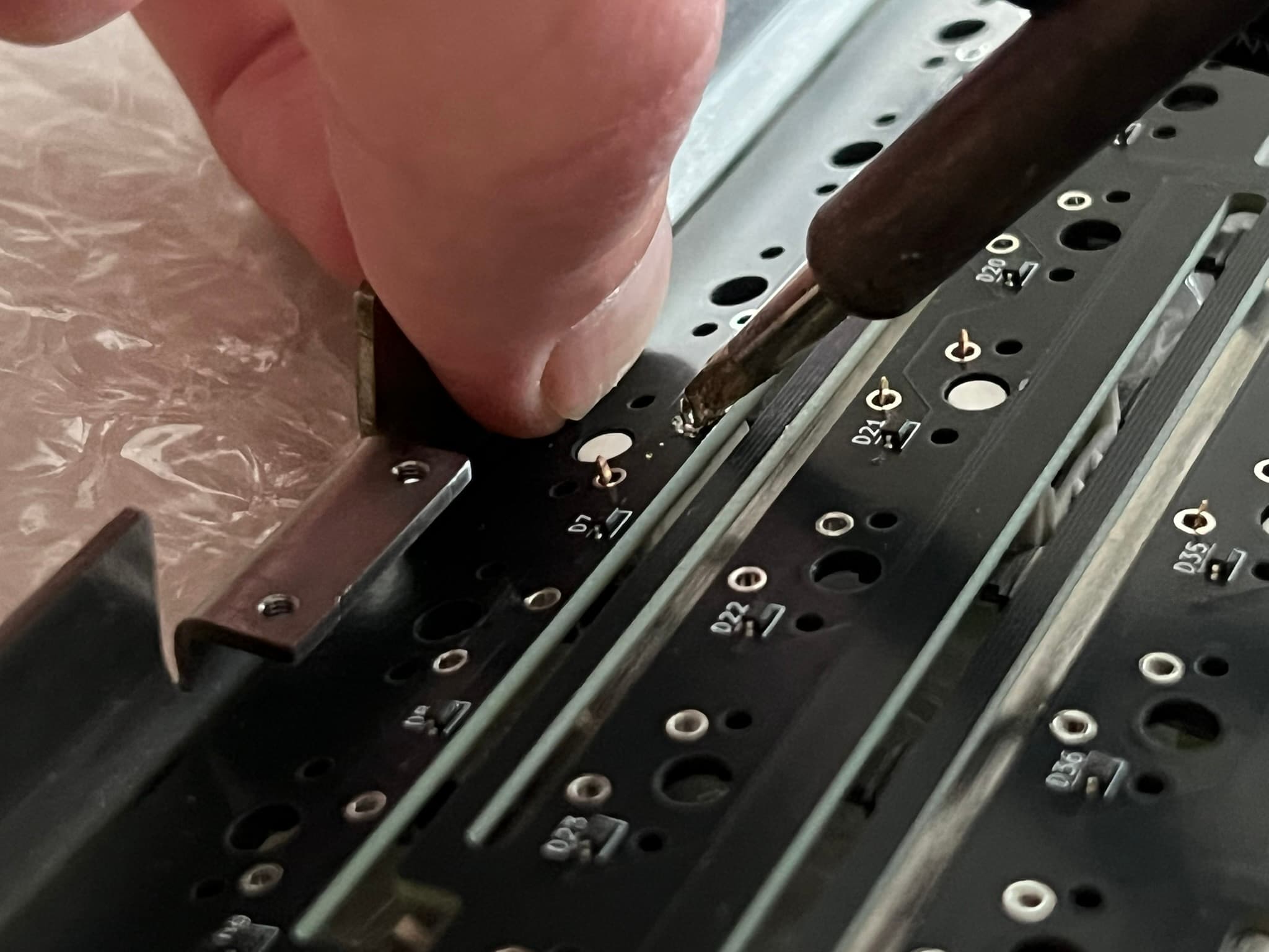 Pushing the PCB flush with the switch as the solder is remelted to allow it to move into place